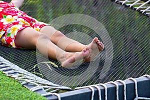 some baby legs in orange shorts is lying on the net, Summer lifestyle concept