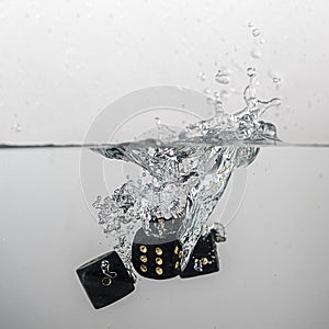 some black game dice drop in water with a splash