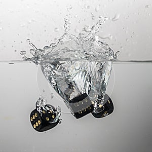 some black game dice drop in water with a splash