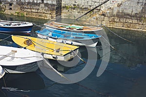 Some boat bright colors on background blue water lake of pier, fishing and boating on summer landscape, holiday travel and sun