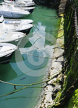 Some boat bright colors on background blue water lake of pier, fishing and boating on summer landscape, holiday travel and sun