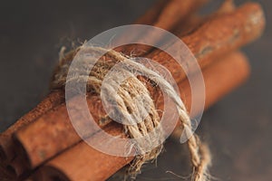 Some cinnamon sticks in bundle on dark background