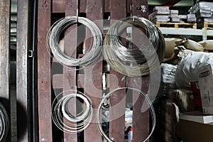 Some coils of fechral thick refractory wire hangs in a warehouse of goods for ceramists. Frame of coiled nichrome wire for heating photo