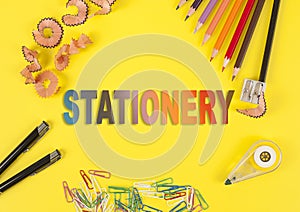Some colored pencils of different colors and a pencil sharpener and pencil shavings on the yellow background. Word Stationery