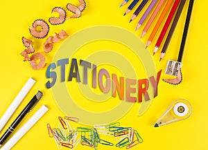 Some colored pencils of different colors and a pencil sharpener and pencil shavings on the yellow background. Word Stationery