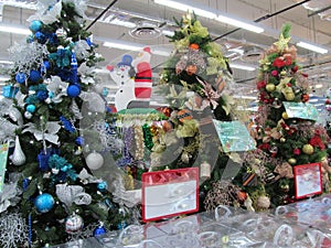 Some colourful christmas trees with decorations at a departmental store