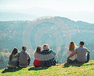 Some Couple travelers Boys and Girls sitting on cliff happy emotions Lifestyle concept Young family traveling active