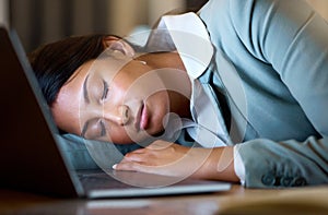 Some days are longer than others. an attractive young businesswoman sleeping on her desk while working late at the