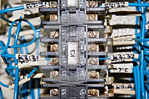 Some electrical relay is mounted on the mounting panel. Relays inserted in the base or socket. Industrial background.