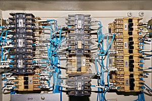 Some electrical relay is mounted on the mounting panel. Relays inserted in the base or socket. Industrial background.