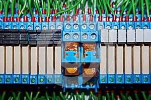 Some electrical relay is mounted on the mounting panel. Relays inserted in the base or socket. Industrial background.