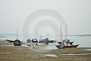 Some fishing boats are stationed on the dry river in winter