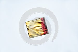 Some flammable red fire matches gathered in a small match box before a white background