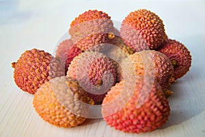 Some fresh lychees on a white cutting board