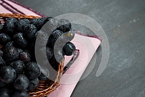 Some grapes in a baskets on a black table
