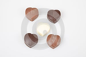 Some heart dark milk chocolate pralines in top view in white background