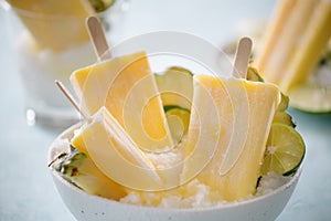 Some homemade Pineapple Popsicles selective focus on a rustic background