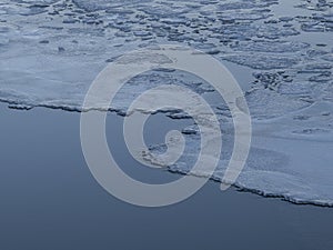 some ice floes along the shore line in the water