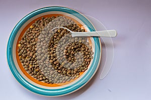 Some lentils on a plate with a spoon in it.