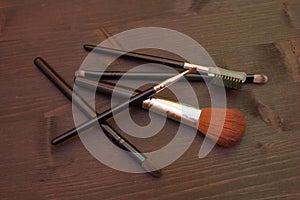 Some makeup brushes on wood seen from above