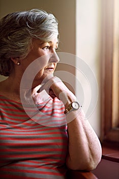Some memories never fade. a senior woman looking thoughtful.