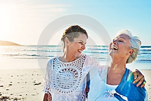 Some much needed mother and daughter time. a senior woman and her adult daughter spending a day at the beach.
