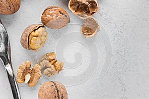 Some open walnuts and metal nutcracker