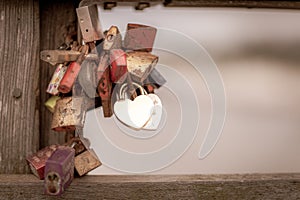 Some Padlocks in different colours hanging from a pier