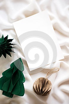 some pine trees next to paper and a string ball on a white cloth