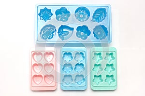 Some plastic ice cube mold trays of different colors