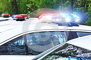 Some police cars with focus on siren lights. Beautiful siren lights activated on a police car before leaving the department park.