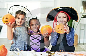 Some pumpkin party fun. Shot of a group of little children showing their carved pumpkins at a party.
