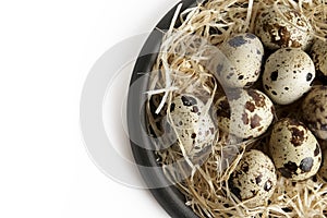 Some quail eggs in a black ceramic bowl