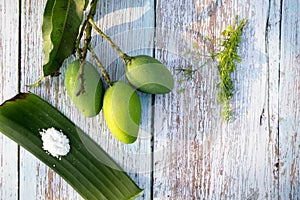 Some raw mango or kaccha aam with some ingrediants like chilli, salt, pudina and garden presly