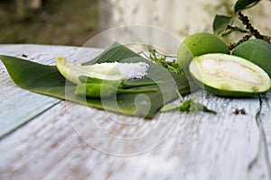 Some raw mango or kaccha aam with some ingrediants like chilli, salt, pudina and garden presly