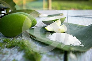 Some raw mango or kaccha aam with some ingrediants like chilli, salt, pudina and garden presly