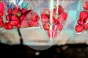 Some red fruits in clear plastic bags