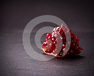 Some red pomegranates on black slate plate