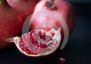 Some red pomegranates on black slate plate