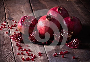 Some red pomegranates on old wooden table