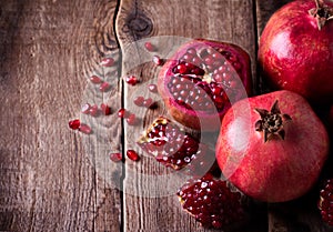 Some red pomegranates on old wooden table