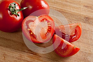 Some red tomatos on cutting board