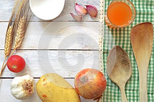 Some repice ingredients on a white wooden table decorated with a green tablecloth.