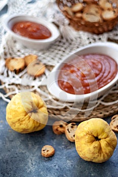 Some ripe quince fruits, ready to make a sweet quince jelly. Quince jelly in a white crokery container. Quince fruit close up