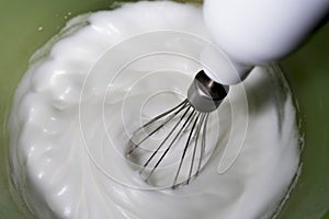 Some rods making meringue in a yellow bowl. photo