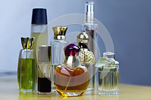 Some rows of perfume bottles on wooden table. Old vintage perfumes.