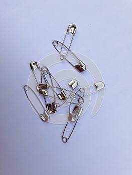 Some safety pins on a white background