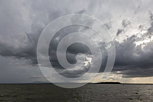 Some spectacular and menacing clouds over a lake, with a distant