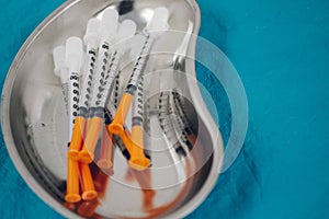 some syringes in a steel medical tray, medical items, taking biomaterial