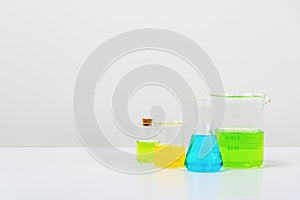 some test tube on the white table with beakers, flasks, and test tubes filled with colorful liquids